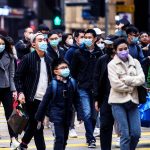 Pedestrians Wearing Face Masks Cross A Road
